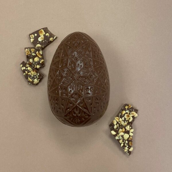 Photo oeuf de Pâques chocolat au lait et plaques de chocolat avec des noisettes